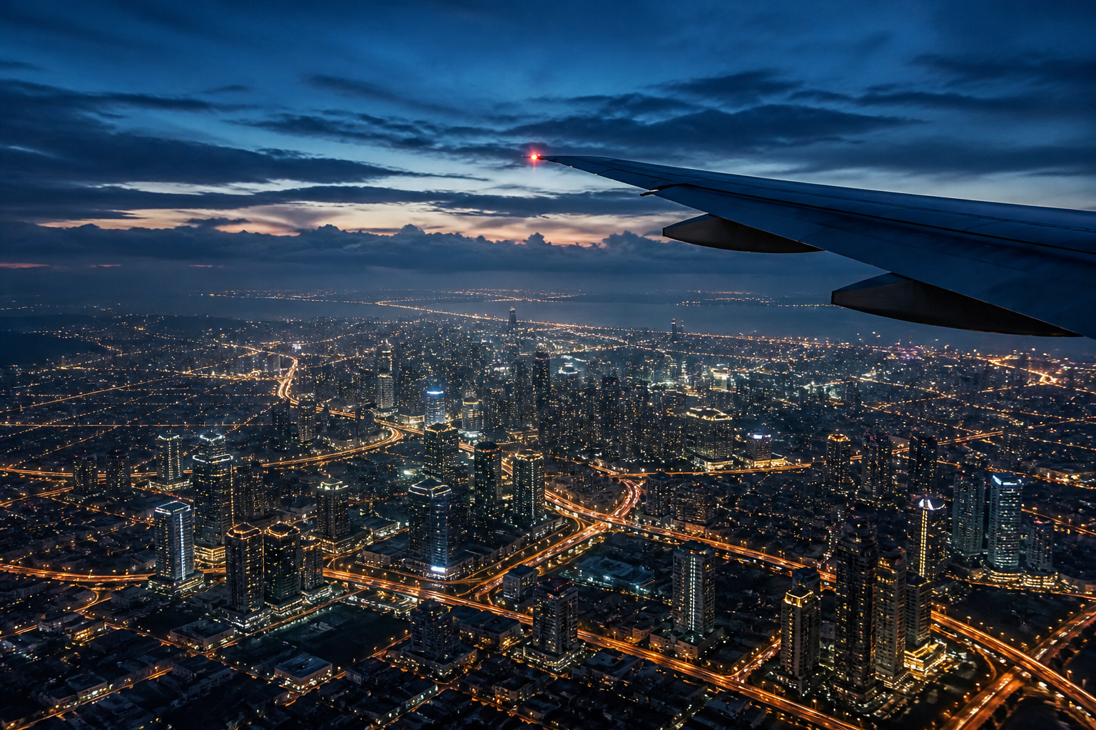 Airplane wing above Jakarta after sunset